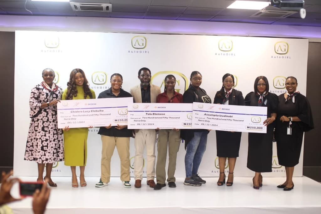 Group celebrating AutoWomen Empowerment Grant cheques with Access Bank and AutoGIRL branding